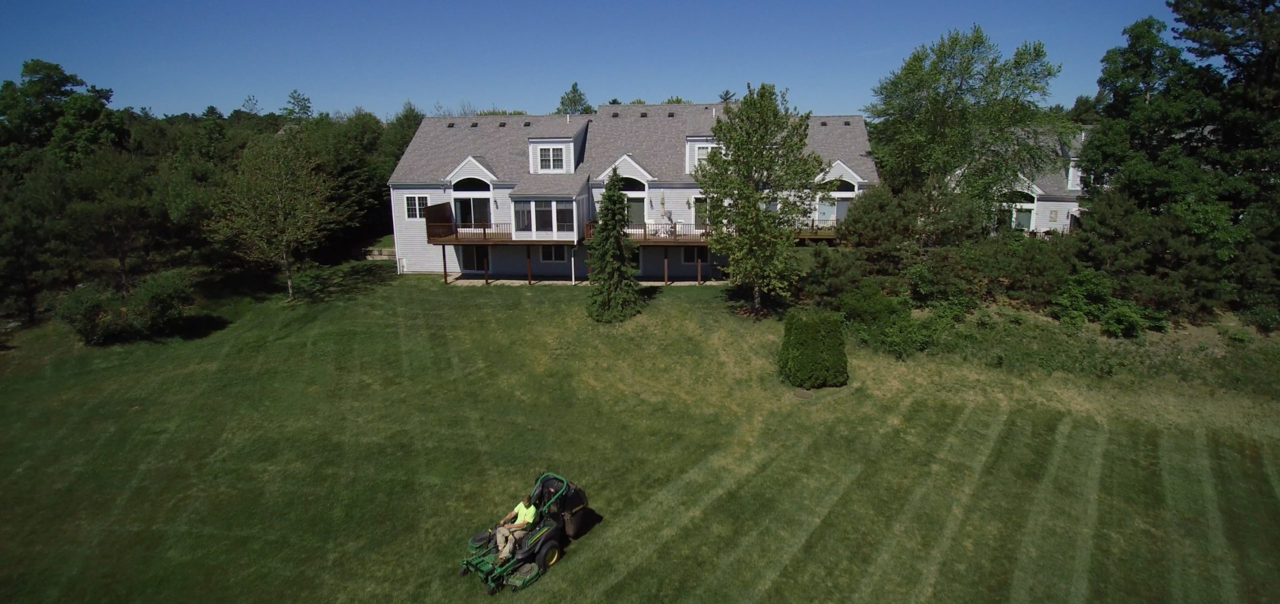 Drone shot of a Greenscape employee mowing at Bourne Condos